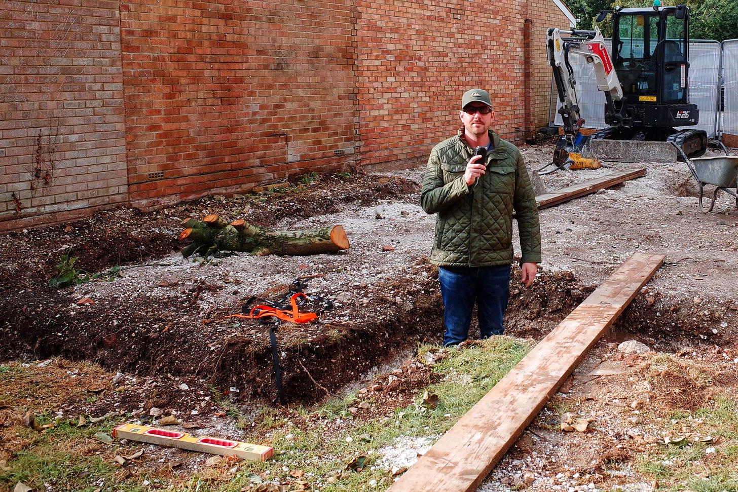 Rob Lambert stood in a trench recording a podcast
