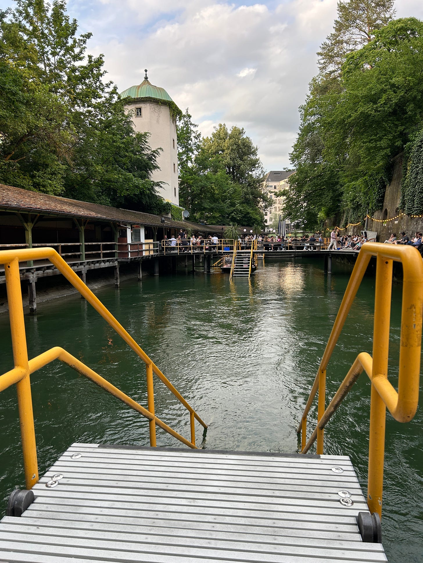 A photo of a river running between the courtyard of a bar