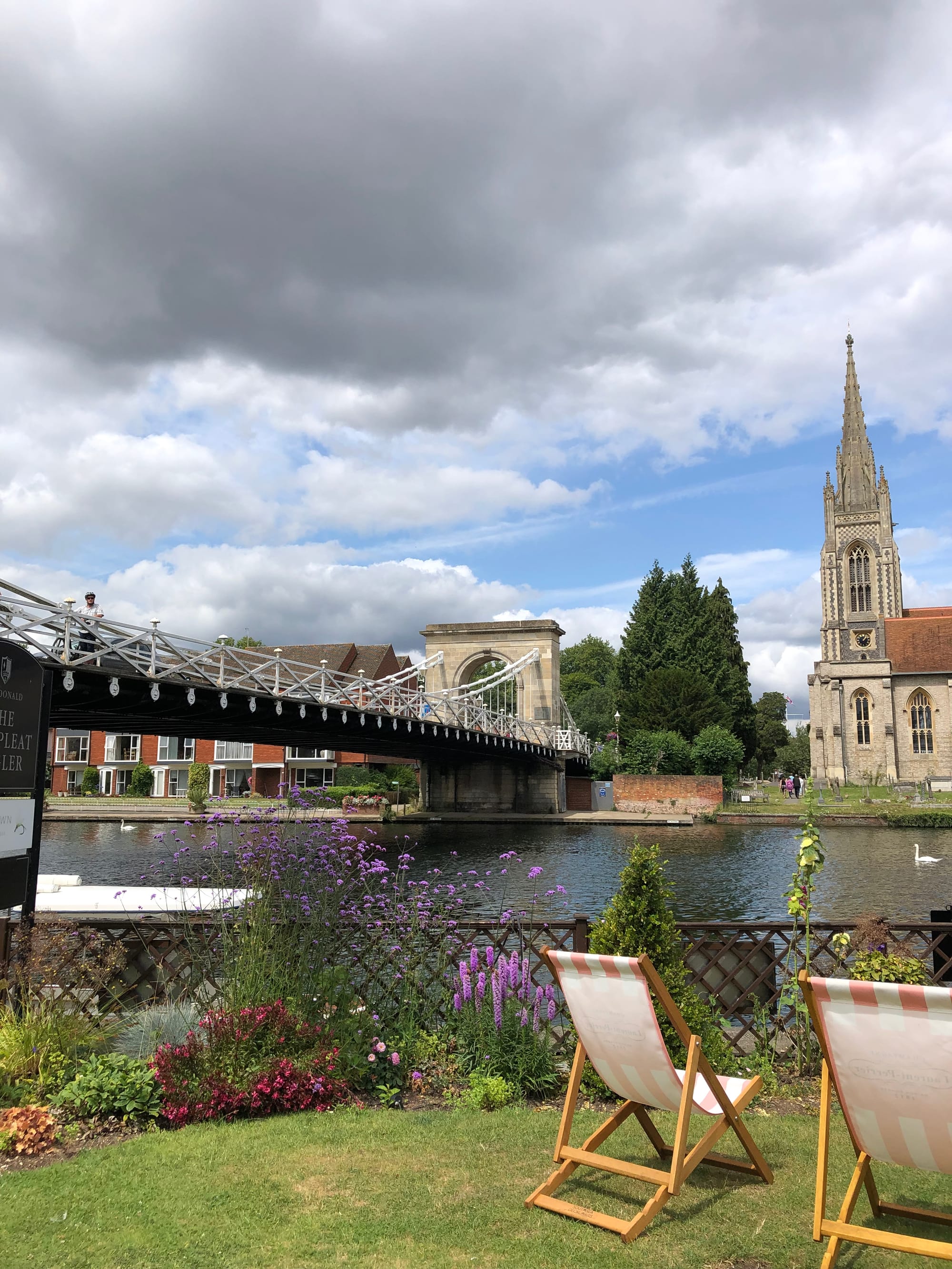 A photo of some deck chairs by a river