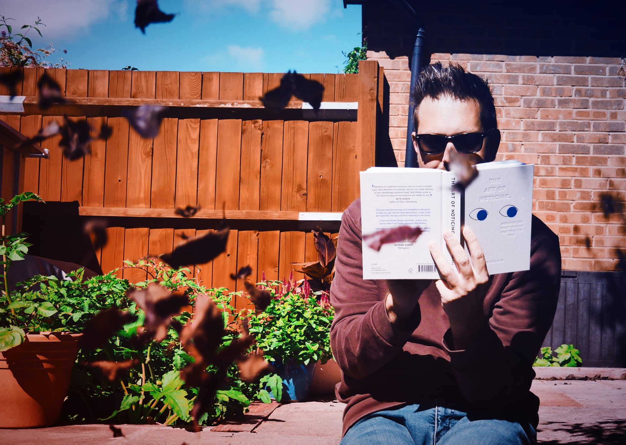 A photograph of Rob Lambert reading the book The Art of Noticing