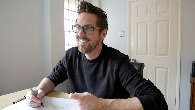 An image of Rob Lambert filling in the A3 sheet - and his sons making him laugh